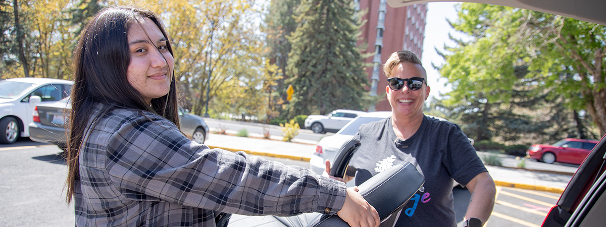 a student and staff member move an office chair
